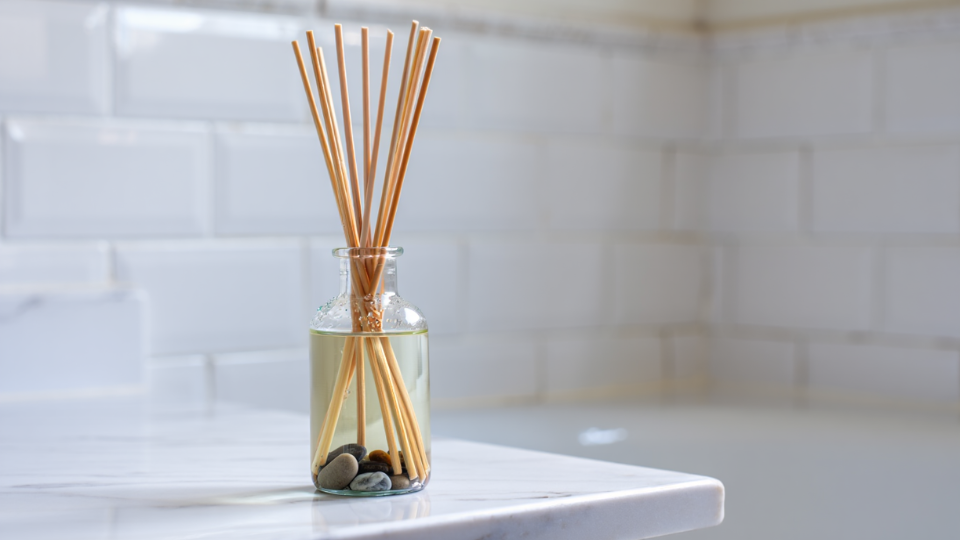 Difusor de varetas exalando uma fragrância suave, um elemento essencial para manter o ambiente de um banheiro limpo e cheiroso e acolhedor.